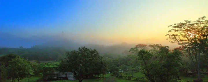 Warm sunrise light above the tree-covered countryside
