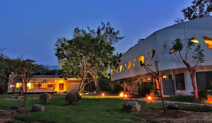 The illuminated Yoga Wellness Center and lawn under a blue evening sky